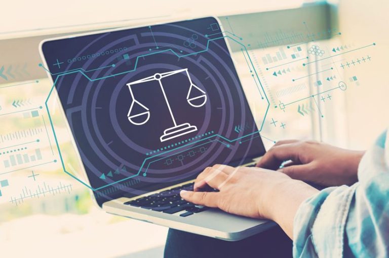 Hände tippen auf einem Laptop mit Balance-Symbol und digitalem Hintergrund.