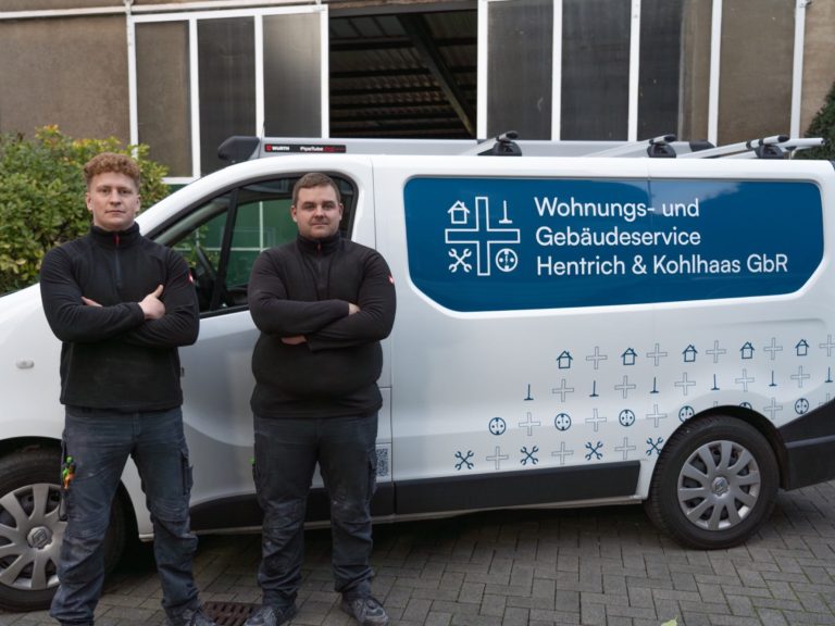 Hände umschließen ein Modellhaus, symbolisieren Schutz und Sicherheit.